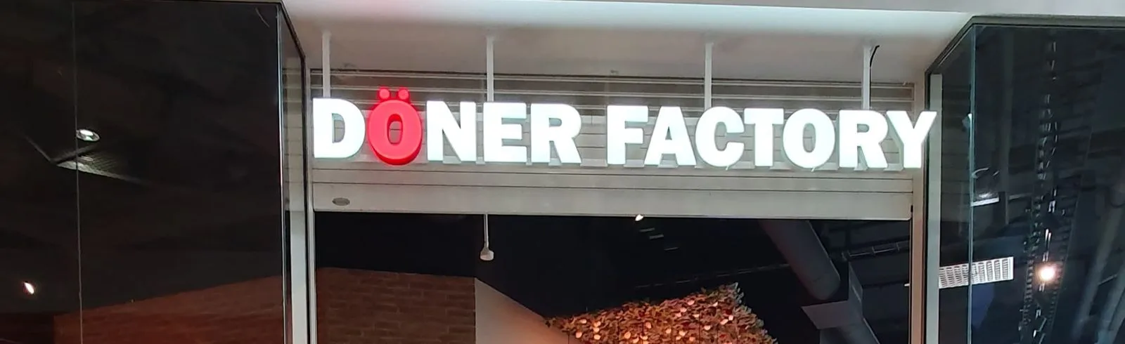 Close-up view of the illuminated Doner Factory logo.